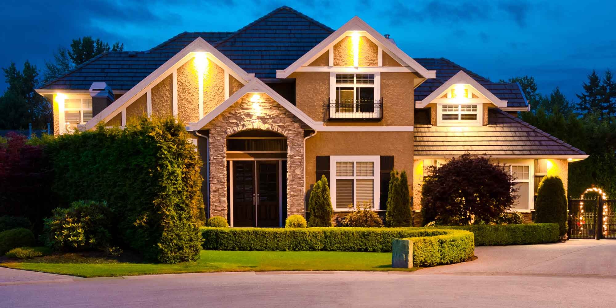 A large home at dusk with warm exterior lighting